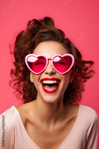 Happy young woman with heart glasses and pink background	