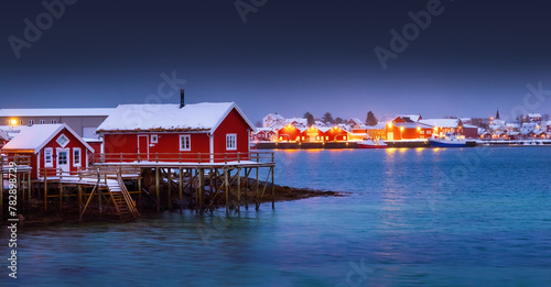 Scenic night lights of Lofoten islands, Norway, Reine and red houses in fishing village on a sea shore.