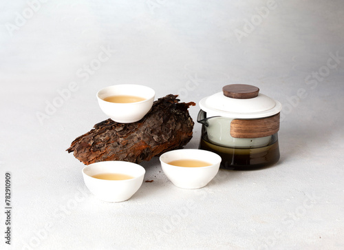 Asian tea set with a teapot and cups on white background woth wood decoration