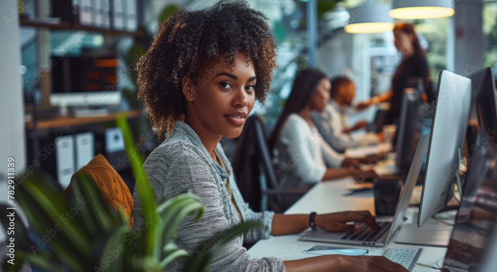 A group of diverse people worked together in an office, each focused on ...