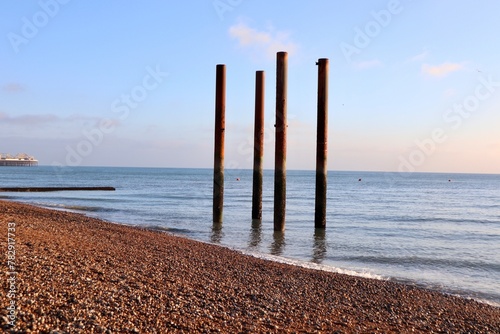 Chimney poles standing on the beach at sunset in Brighton, England photo