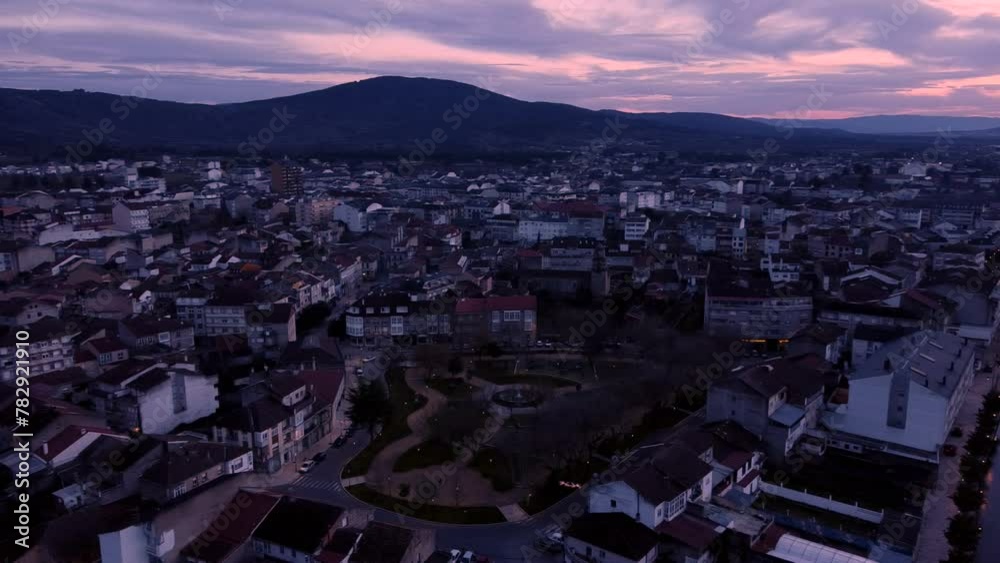 Aerial shot of the urban town at sunset with hills in distance Aerial shot of the urban town at sunset with hills in distance
