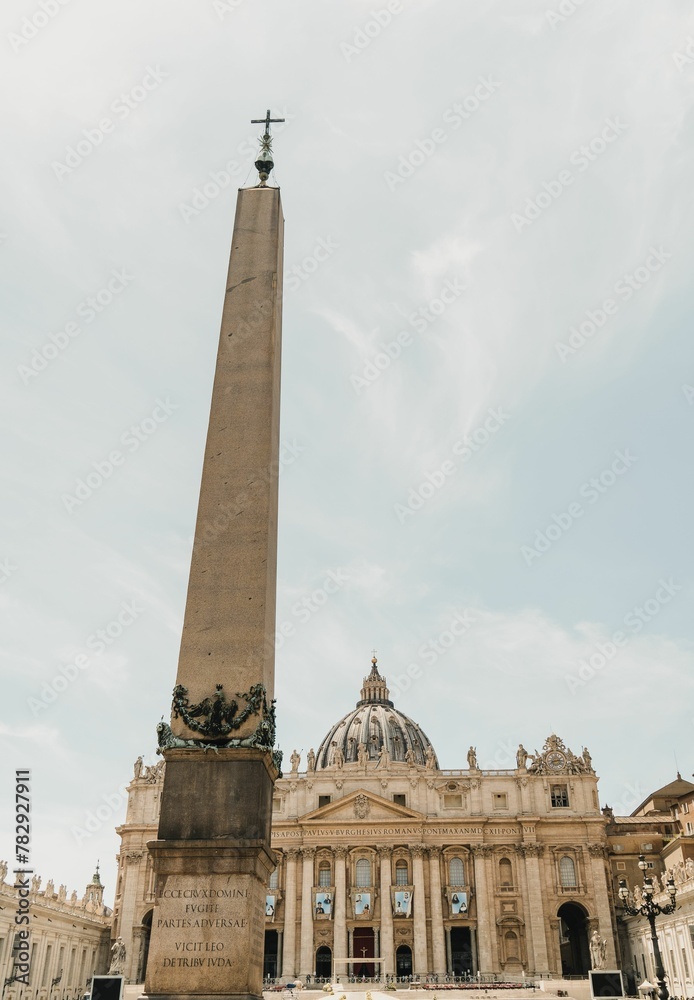 Vertical shot of the obelisk with a background of St. Peter's Basilica in Vatican City