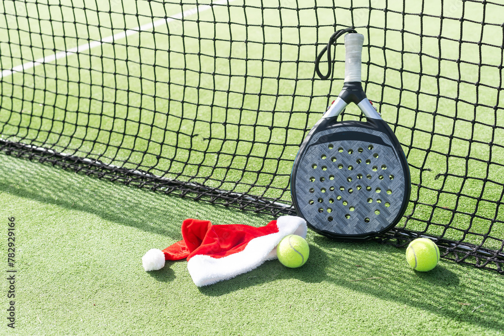Obraz premium padel racket and santa hat