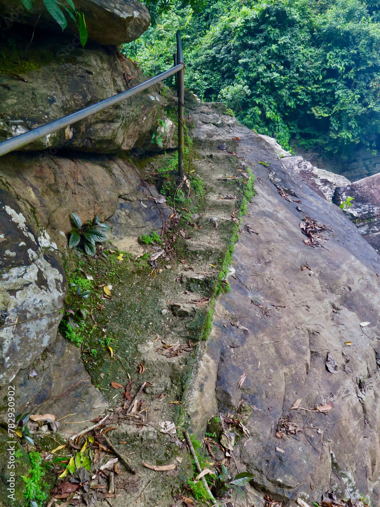 Obraz premium Stone stairs in the mountains. Staircase carved in stone in the jungle. Steps carved in stone lead up. Stone staircase and iron railing.
