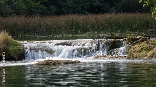 Scenic view of a river flowing through rocks in a green forest in Croatia