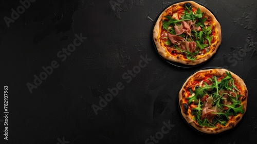 two gourmet pizza slices adorned with savory prosciutto and fresh arugula, elegantly arranged in a flat lay composition against a sleek black background, viewed from the top.
