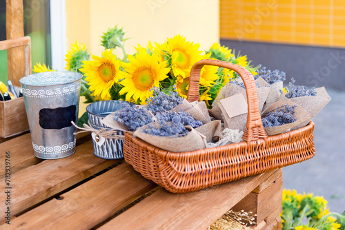Basket of flowers on the table on the street. Sunflowers and lavender.