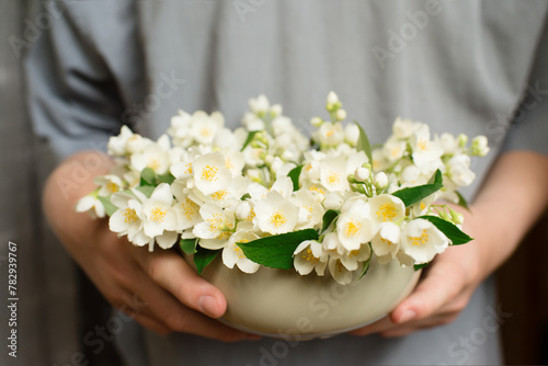 Jasmine flowers, male hands holding a bouquet in a vase. Wedding, birthday, mother's day. Beautiful flower arrangement.