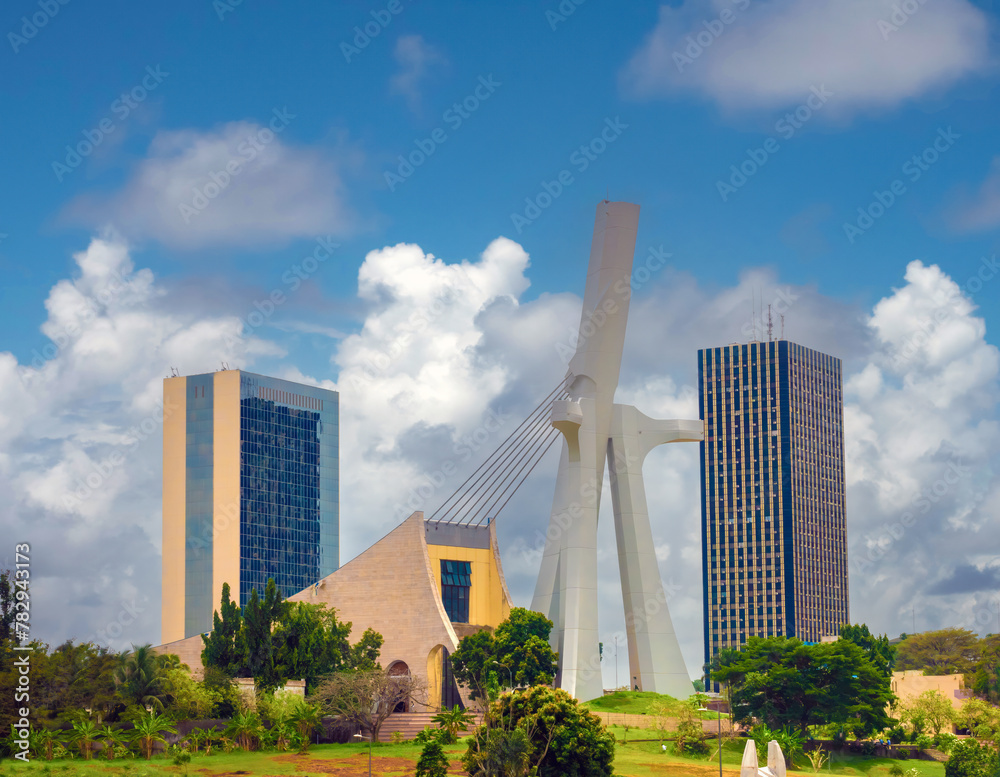 The modern skyline of the plateau district of Abidjan with St. Paul Cathedral in the foreground Abidjan, Côte d'ivoire (Ivory Coast), West Africa - obrazy, fototapety, plakaty 