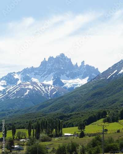 Vertical shot of a beautiful landscape with tree-covered hills and high mountains