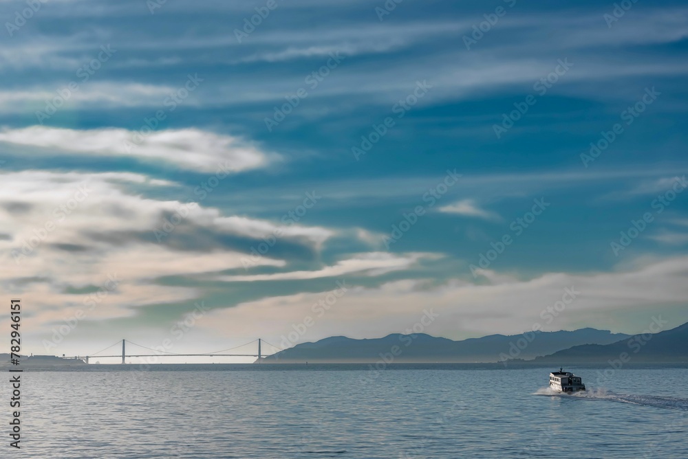 Beautiful scene of San Francisco Golden Gate Bridge Bay over shiny water at sunset o the horizon Beautiful scene of San Francisco Golden Gate Bridge Bay over shiny water at sunset o the horizon