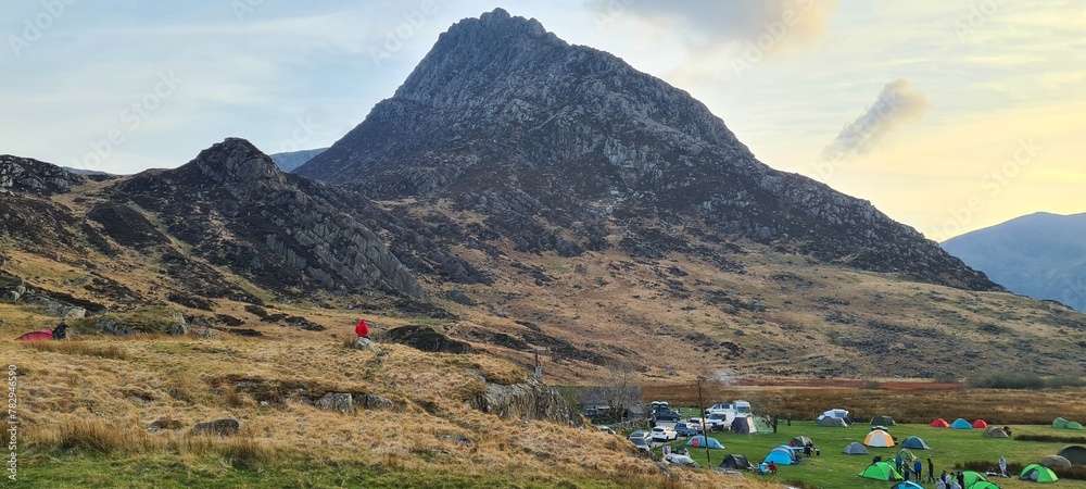 Beautiful shot of camping tents placed under a huge Glyder Fach mountain