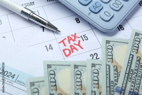 Calendar with date reminder about tax day, money, pen and calculator, closeup