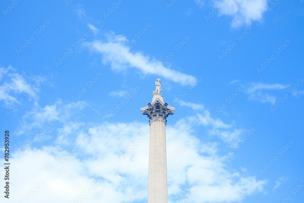 Low angle shot of Nelson's Column against a calm blue sky background