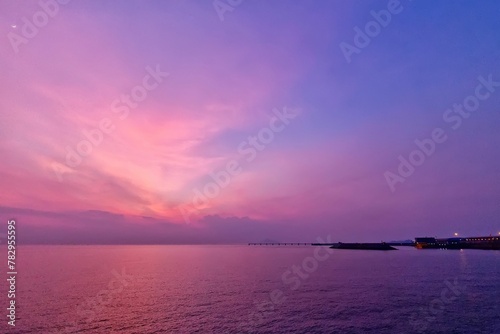 sunset in an empty bay with a bridge leading to it © Wirestock