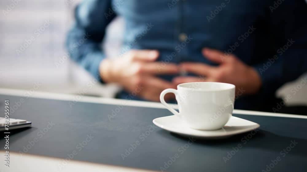 Man Suffering From Stomach Pain With Cup Of Coffee Man Suffering From Stomach Pain With Cup Of Coffee