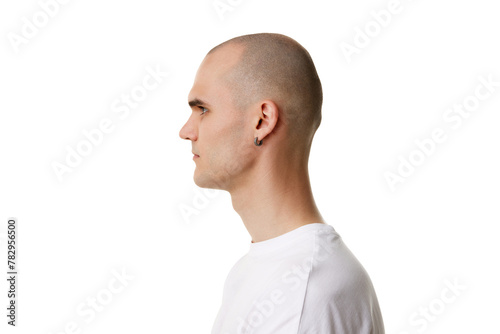 Schilderij op canvas Side, profile view of young man with bald head and shaved face, ear piercing standing in white t-shirt isolated on white background