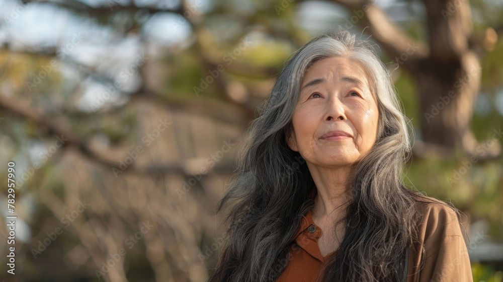 A woman with long gray hair wearing a brown shirt. Suitable for various lifestyle and fashion concepts