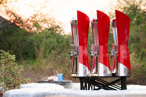 Three red beer towers on a black table with a forest background.