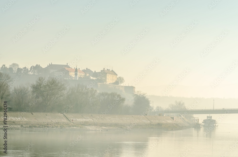 Historic castle building and the River Danube covered in mist in Novi Sad, Serbia