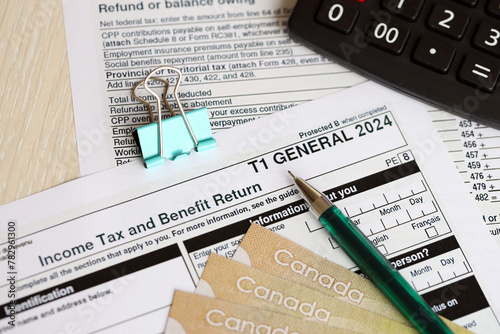 Canadian T1 General tax form Income tax and benefit return lies on table with canadian money bills close up. Taxation and annual accountant paperwork in Canada