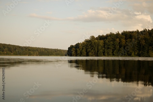 Clear lake with the trees reflection on the water © Wirestock