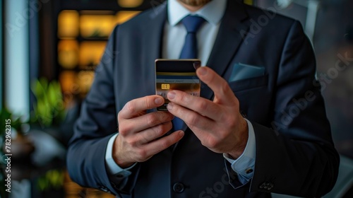 Cheerful and smiling bearded businessman doing online shopping and bank money transfer, freelancer holding bank credit card and smart phone photo