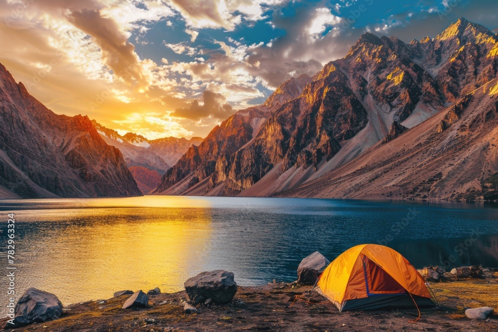 An orange tent by a tranquil mountain lake as the sun sets behind the peaks. Perfect for adventure and travel themes. Generated AI