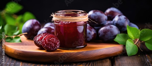 Fresh plums and plum jam on wooden board