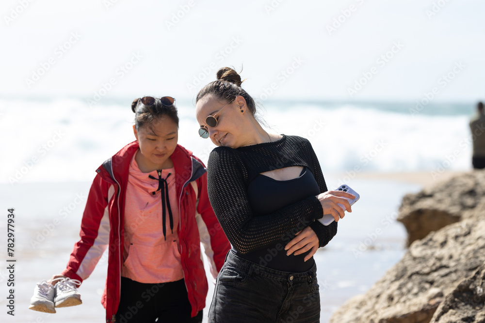 Woman and Young Girl Walking on the Beach