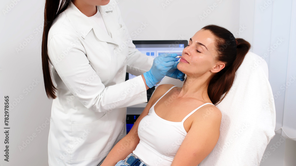 Obraz premium Consultation with a cosmetologist or dermatologist. Before the procedures, the woman is examined by a cosmetologist and receives recommendations on facial cleansing, lifting or injections.