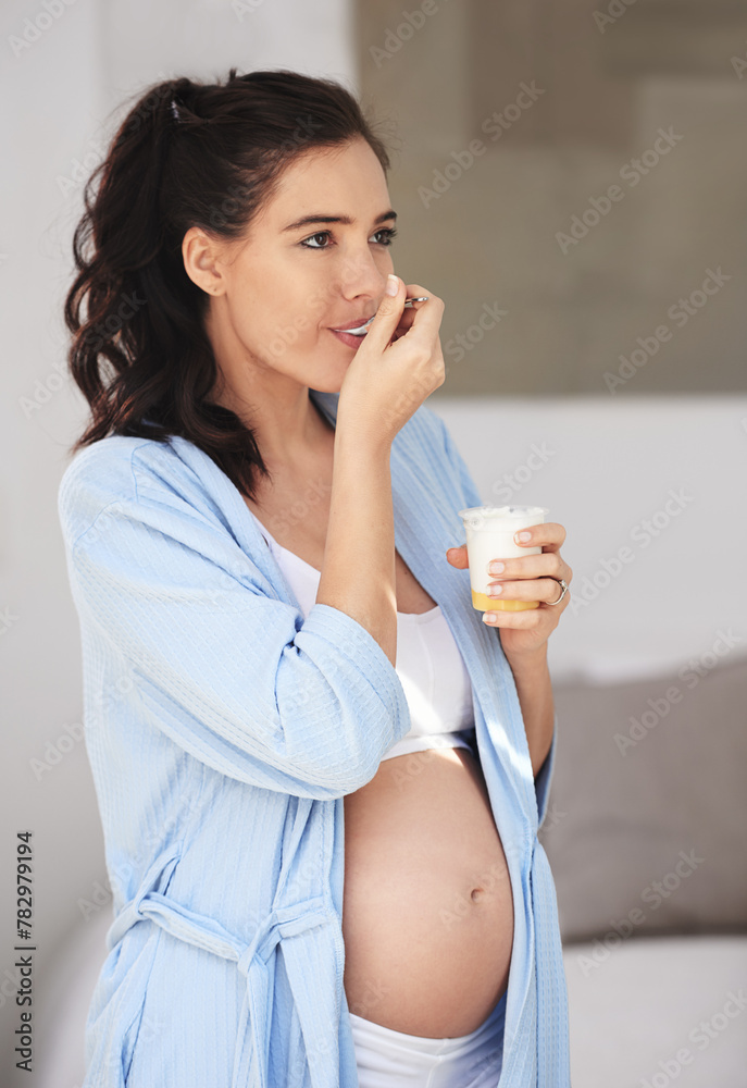 Pregnancy, eating and woman at home with yogurt for snack, craving and nutrition in bedroom. Pregnant person, abdomen and dessert or ice cream for vitamin, protein and wellness for belly or stomach Pregnancy, eating and woman at home with yogurt for snack, craving and nutrition in bedroom. Pregnant person, abdomen and dessert or ice cream for vitamin, protein and wellness for belly or stomach