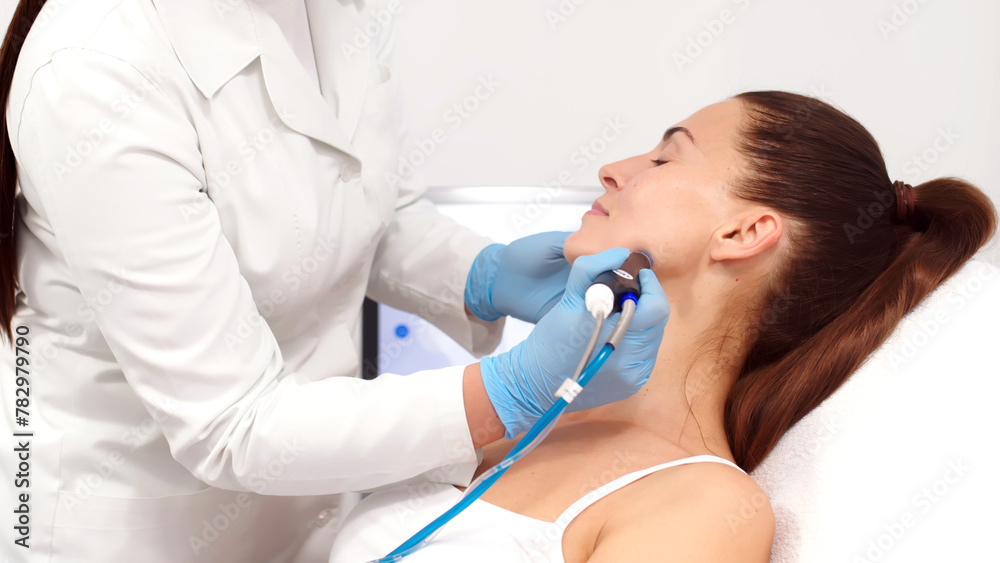 A cosmetologist performs vacuum cleaning and polishing of the facial skin of a middle-aged woman in a cosmetology clinic. Professional moisturizing and rejuvenating hardware procedures. A cosmetologist performs vacuum cleaning and polishing of the facial skin of a middle-aged woman in a cosmetology clinic. Professional moisturizing and rejuvenating hardware procedures.