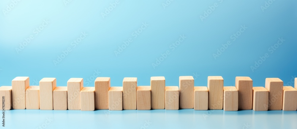 Wooden blocks lined up on blue backdrop Wooden blocks lined up on blue backdrop
