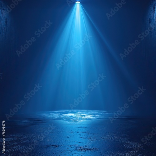 A spotlight shines down on a wet concrete floor.