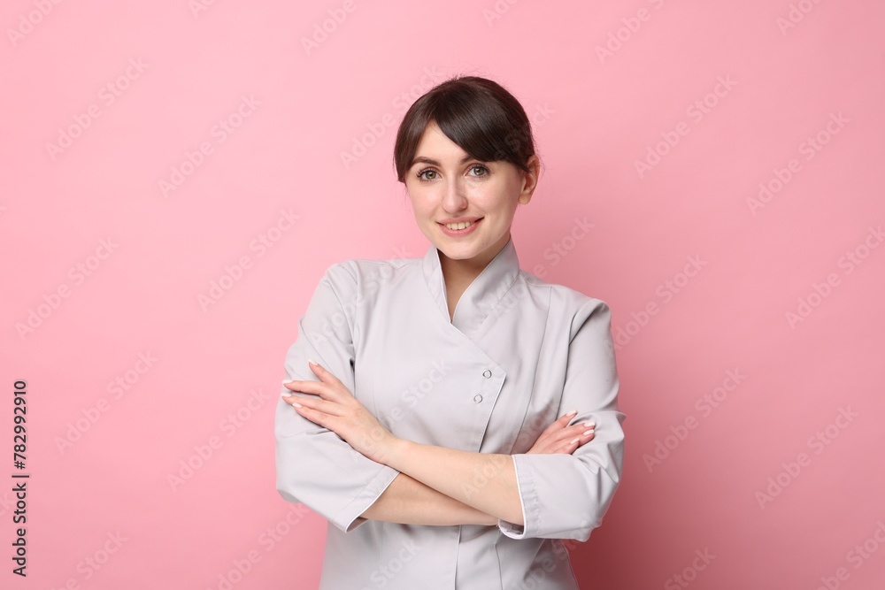 Cosmetologist in medical uniform on pink background Cosmetologist in medical uniform on pink background