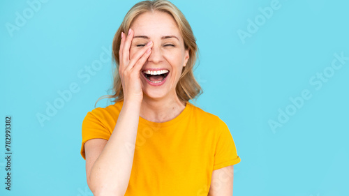 Overjoyed woman isolated on blue studio background laugh loud.