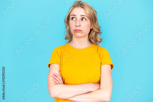 Dreamy thoughtful woman looking up in air. Isolated on blue background.