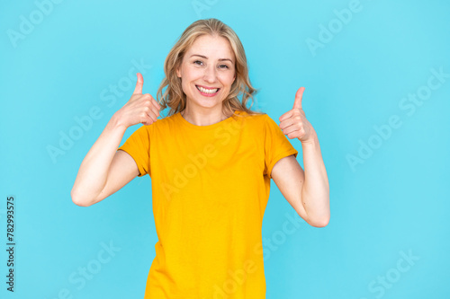 Excited smiling young woman in casual wear showing thumbs up © brizmaker