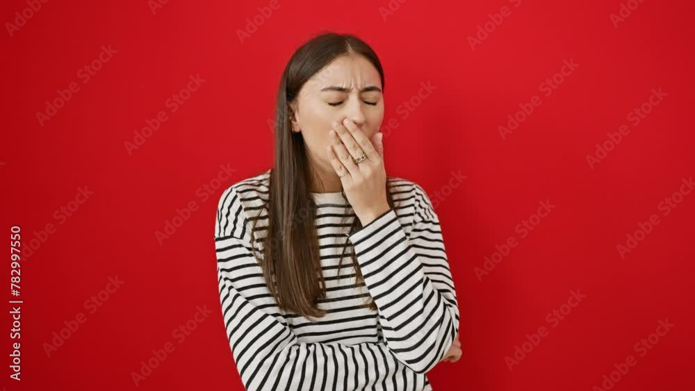 Sick and beautiful - young hispanic woman in striped t-shirt coughing, showing cold or bronchitis symptoms. alone against red background, a portrait of illness and health care struggles.