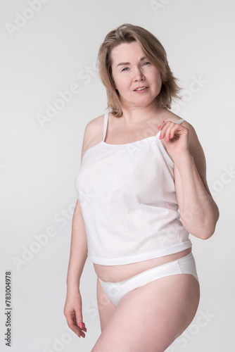 Woman in underwear on white background. Concept is about promoting healthy lifestyle and body inclusivity, particularly for mid adults, those who body conscious, those wear extended sizes or curvy