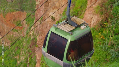 A funicular on the island of Madeira takes people down from a high cliff with an incredible view from above to the ocean and a small picturesque village Achadas da Cruz photo