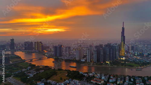 Aerial view of Asia city at sunset by drone with Landmark 81 skycraper modern building  boat on Saigon river  night skyline of Vietnam