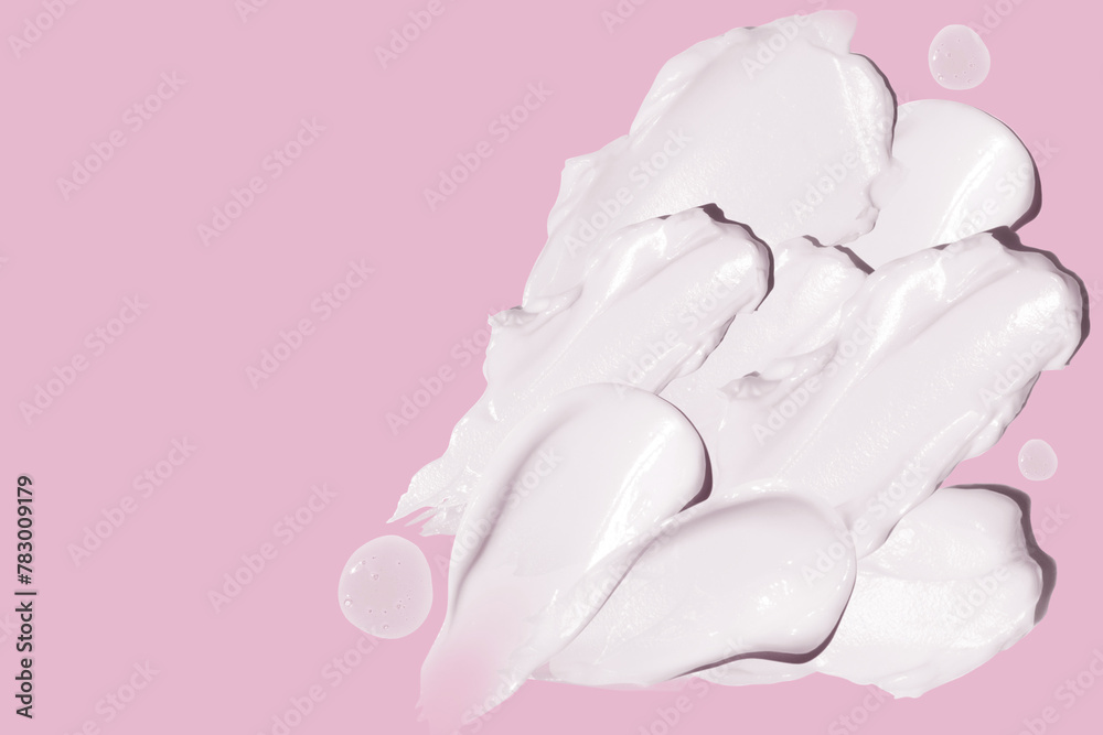smears of cosmetic cream on a pink background.