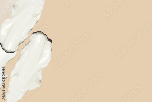 smears of cosmetic cream on a beige background.