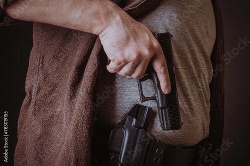 A gun in a holster, delicately hidden under his shirt.