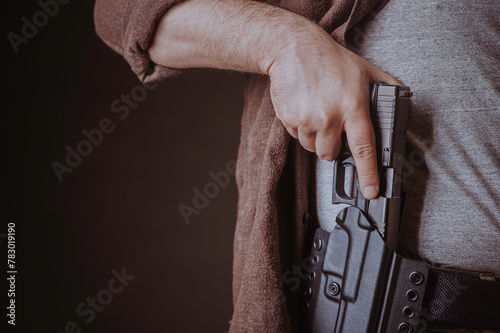 A gun in a holster, delicately hidden under his shirt.