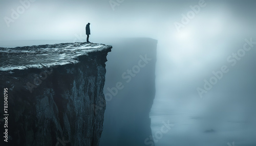 A lone silhouette stands precariously at a cliff's edge - representing the feelings of entrapment and desperation that victims of abuse might experience -wide