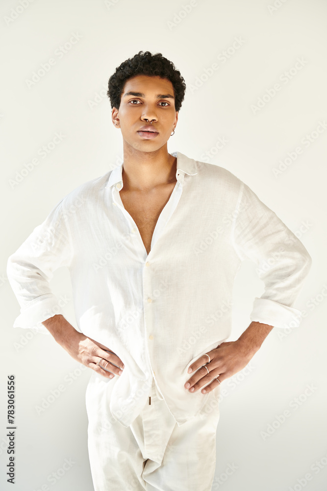 fashionable young african american man in white attire and looking at camera on beige backdrop fashionable young african american man in white attire and looking at camera on beige backdrop